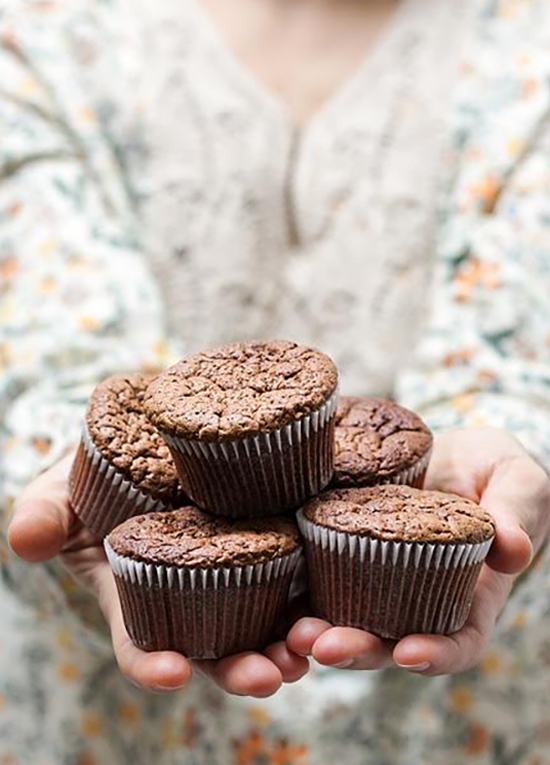 Hands holding freshly baked muffins