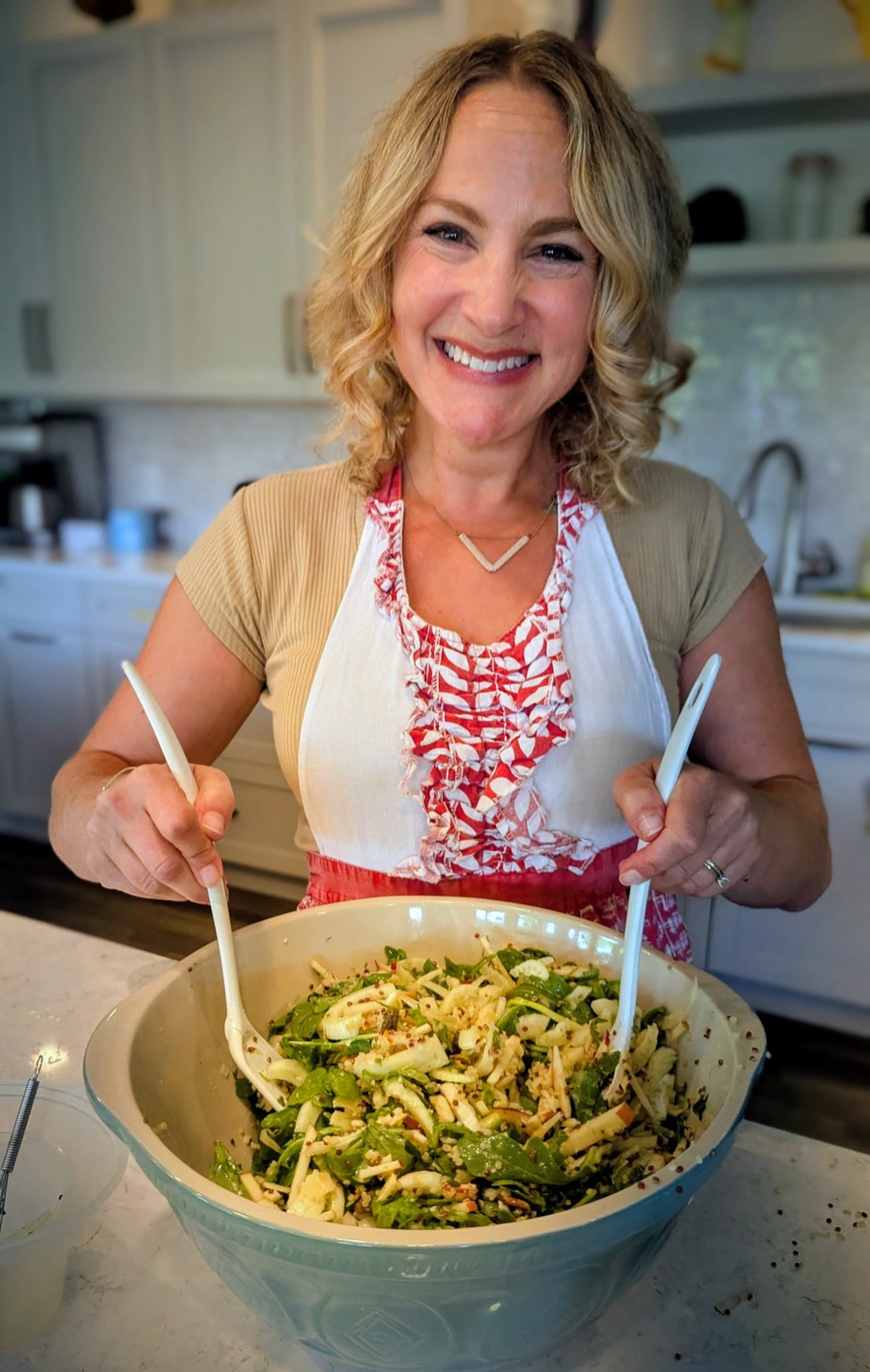 Robin Glance tossing a fresh salad in her kitchen